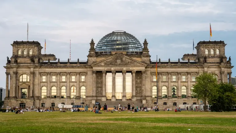 Weitwinkelaufnahme des Reichstagsgebäudes vor blauem Himmel mit dem Platz der Republik.