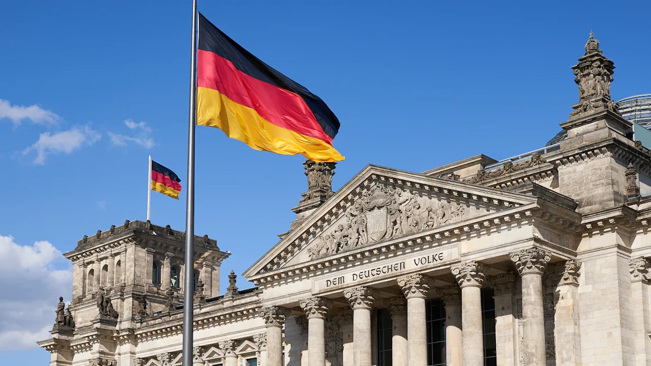 Die deutsche Flagge weht vor dem historischen Reichstagsgebäude in Berlin.