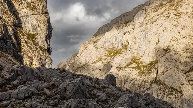 Felsige Berglandschaft unter bedrohlichem, dunklem Wolkenhimmel im Picos de Europa Gebirge.