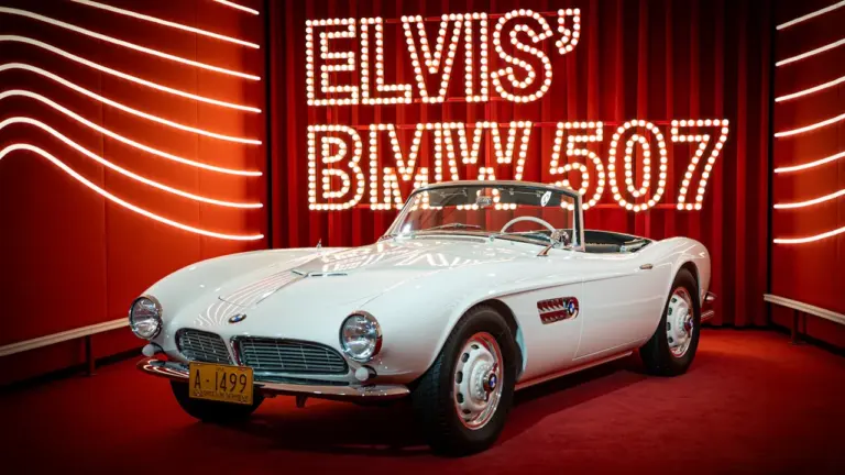 Elvis Presleys berühmter weißer BMW 507 als Ausstellungsstück auf einer roten Plattform.