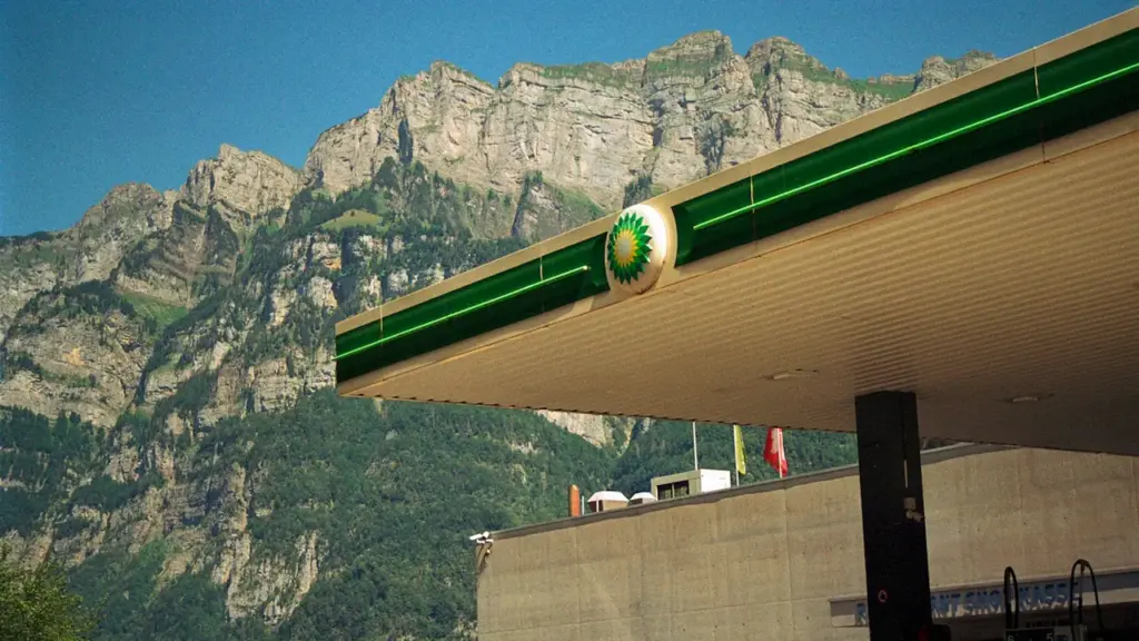 Eine Tankstelle vor einer beeindruckenden Bergkulisse bei strahlend blauem Himmel.