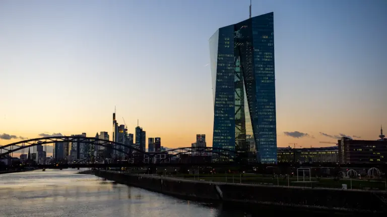 Blick bei Sonnenuntergang auf die Europäische Zentralbank und die Frankfurter Skyline.