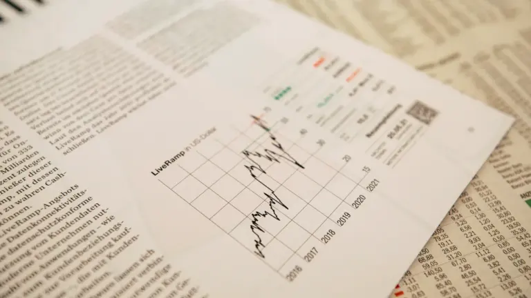 Wirtschaftszeitung mit einer grafischen Darstellung von Aktienkursen und Finanzdaten in Nahaufnahme.