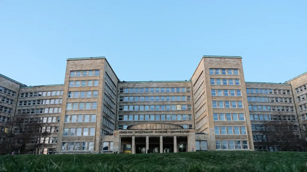 Die imposante Fassade des Goethe-Universität Hauptgebäudes vor einem klaren, blauen Himmel.