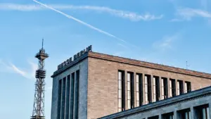 Modernes Messe Berlin Gebäude mit hohem Funkturm unter blauem Himmel.