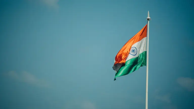 Die indische Flagge weht im Wind vor einem klaren blauen Himmel.