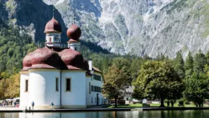 Die berühmte Wallfahrtskirche St. Bartholomä am Königssee vor einer beeindruckenden alpinen Bergkulisse in Bayern.