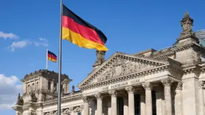 Die deutsche Flagge weht vor dem historischen Reichstagsgebäude in Berlin.