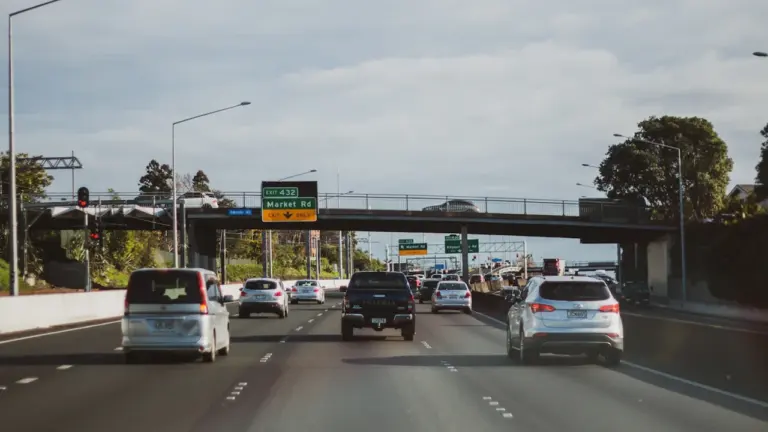 Autoverkehr auf einer Autobahn bei Tageslicht vor einer Brücke.