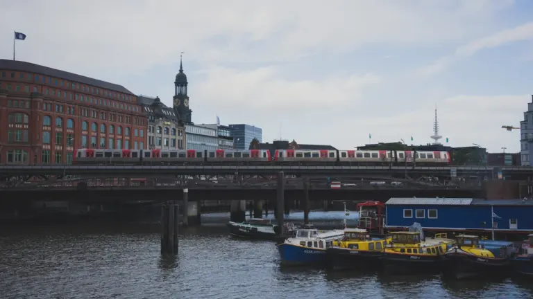 Eine Hamburger S-Bahn überquert eine Brücke über die Elbe bei Tageslicht.