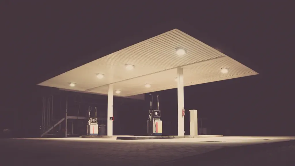 Eine nächtliche Tankstelle in Deutschland mit beleuchteten Zapfsäulen und modernen Gebäudestrukturen.