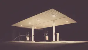 Eine nächtliche Tankstelle in Deutschland mit beleuchteten Zapfsäulen und modernen Gebäudestrukturen.