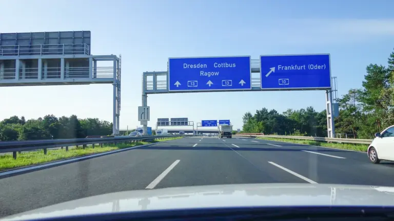 Blaue Autobahnschilder mit Zielangaben wie Dresden und Frankfurt auf einer deutschen Autobahn.