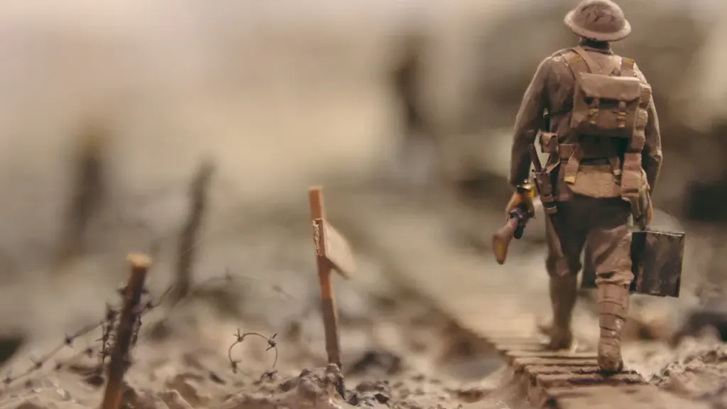 Ein Soldat auf einem Pfad, umgeben von Stacheldraht, symbolisiert den historischen Konflikt des Zweiten Weltkriegs.