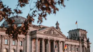 Das Reichstagsgebäude in Berlin bei Tageslicht unter einem blauen Himmel.