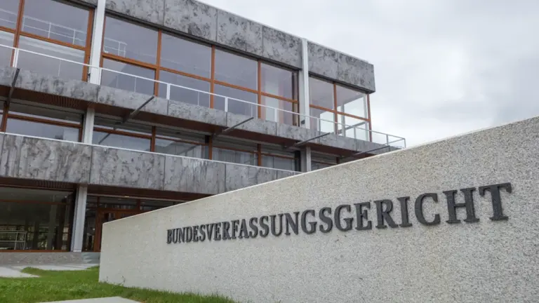 Das Gebäude des Bundesverfassungsgerichts in Karlsruhe mit seinem markanten Namensschild an einer Steinmauer.