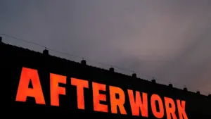 Ein leuchtendes Afterwork-Schild an einem Gebäude in der Dämmerung in Deutschland.