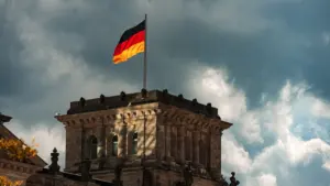 Die deutsche Flagge weht über dem historischen Gebäude des Reichstags in Berlin.