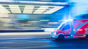 Ein Rettungswagen fährt mit Blaulicht durch eine deutsche Stadt im nächtlichen Einsatz.
