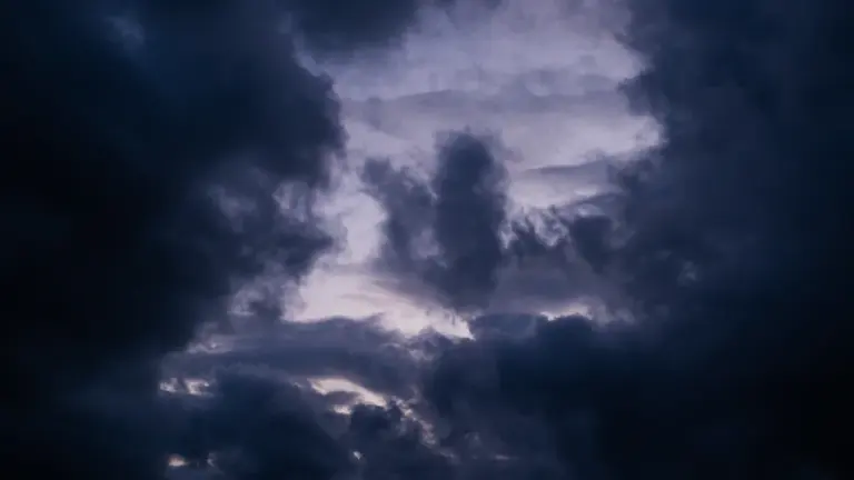 Weißer Wolkenhimmel bei hellem Tageslicht über einer weiten Landschaft.