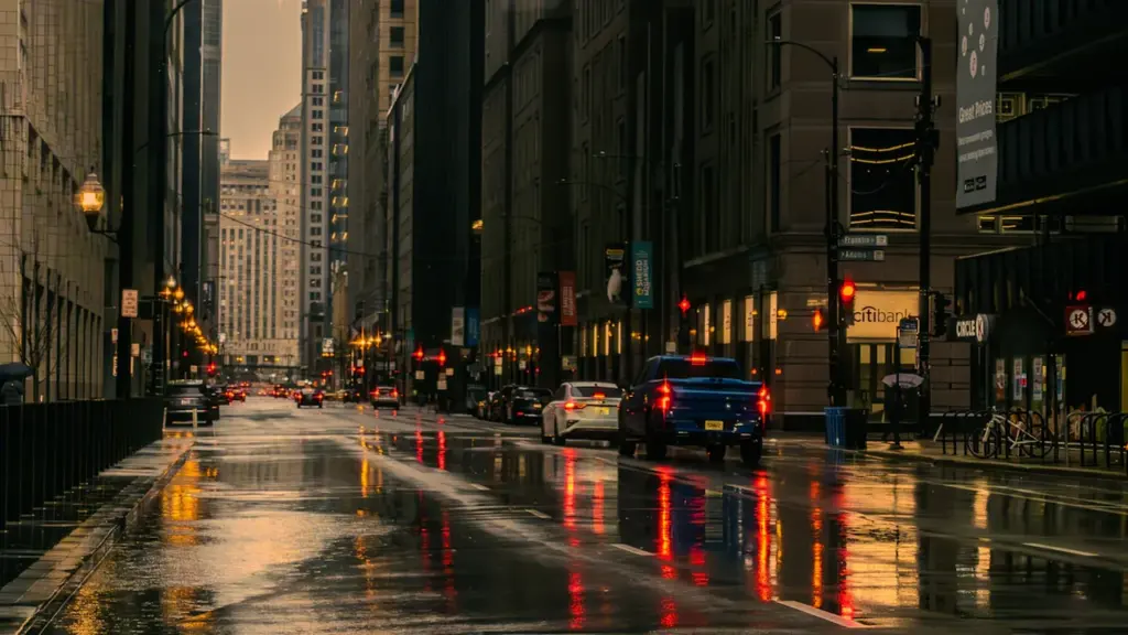 Regennasse Straße in einer Stadt bei schlechtem Wetter mit Autos im Verkehr