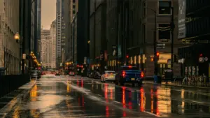 Regennasse Straße in einer Stadt bei schlechtem Wetter mit Autos im Verkehr
