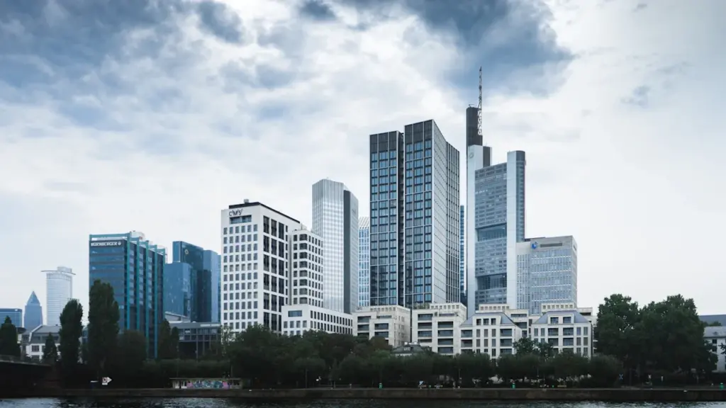 Die monumentale Euro-Skulptur vor der modernen Frankfurter Skyline im Sonnenschein.